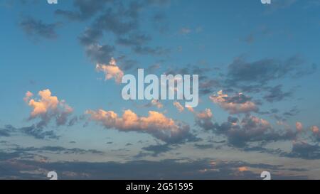 Dunkle und helle Wolken gegen einen blauen Himmel am späten Nachmittag. Stockfoto