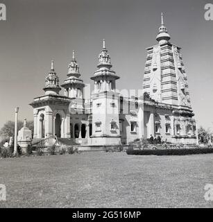 1950er Jahre, historisch, außerhalb des buddhistischen Tempels, mulagandhakuti vihara; Sarnath, Varanasi, indien 'möge alle Lebewesen glücklich sein'. Der Tempel oder das Kloster wurde 1931 von Angarika Dharmapala erbaut und wird von der Mahabodhi-Gesellschaft, von der er gegründet hat, unterhalten und geführt. Stockfoto