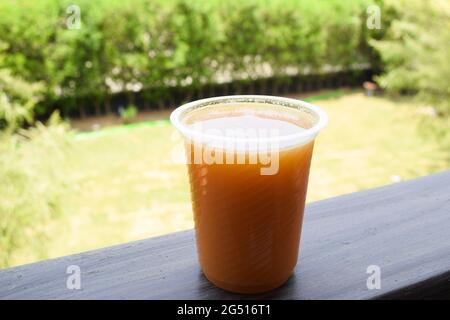 Frisch entsaftet lecker süßen Orangensaft Getränk hausgemachte serviert auf dem Tisch im Hinterhof. Gesundes natürliches Bio-Getränk. Offene grüne Umgebung im Freien Stockfoto
