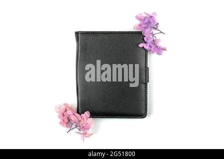 Business-Leder-Notebook-Mockup-Design mit rosa getrockneten Blumen, Draufsicht und Kopierraum, weißer Hintergrund Stockfoto