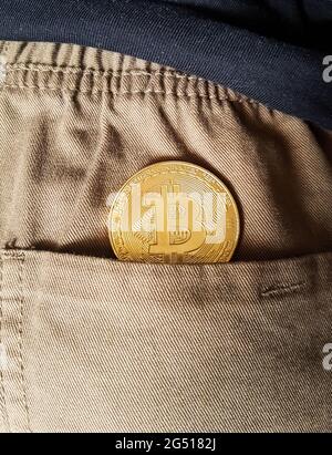 Bitcoin Goldmünze in einer Rückentasche aus Jeans Stockfoto