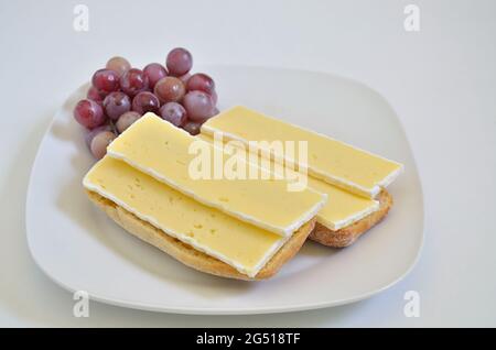 Zwei Sandwiches mit Camembert und Vergewaltigungen auf weißem Teller, Nahaufnahme, isoliert auf weißem Hintergrund Stockfoto