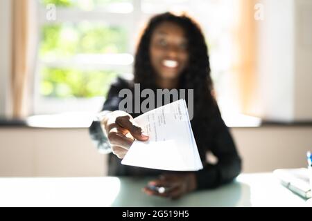 Afrikanische Geschäftsfrau, Die Gehaltsscheck Oder Gehaltsscheck Gibt Stockfoto