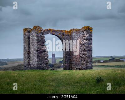 Altes Steingebäude hinter Blackpool Beach in der Nähe von Hartland, North Devon. Die Dorfkirche von Stoke ist in der Ferne sichtbar. Stockfoto