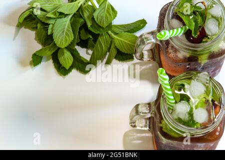 Kalte Getränke in kleinen Flaschen. Kirschen Minzlimonade. Mojito-Coctail. Stockfoto