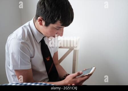 Sekundarschüler, Alter 14 Jahre, der Wickipedia auf seinem Handy liest Stockfoto