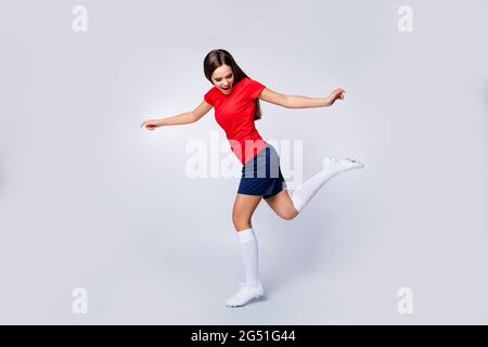 Ganzkörper-Profilfoto der coolen Dame Spieler Fußballmannschaft zeigt Freestyle Tricks Kick Ball Übung tragen Fußball Uniform T-Shirt Shorts Stollen Socken Stockfoto