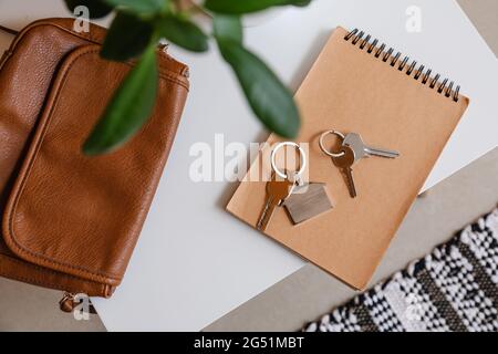 Schlüssel mit Notebook und Tasche auf dem Tisch im Zimmer Stockfoto