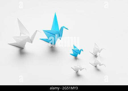 Origami-Vögel auf hellem Hintergrund. Konzept der Einzigartigkeit Stockfoto