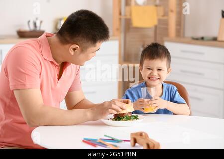 Vater Fütterung seinem kleinen Sohn in der Küche
