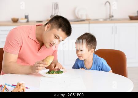 Vater Fütterung seinem kleinen Sohn in der Küche