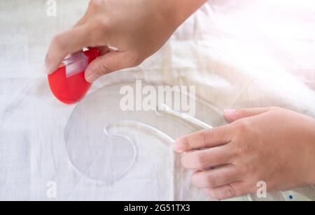 Nahaufnahme der Schneidertisch mit weiblichen Händen zeichnen Stoff mit Kurve Lineal für die Herstellung eines Musters für Kleidung in Werkstatt-Studio. Stockfoto
