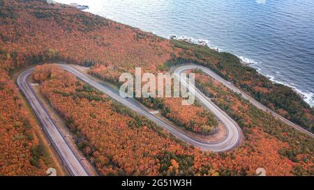 Kurvenreiche und malerische Straßen auf dem weltberühmten Cabot Trail in den MacKenzie Mountains, Cape Breton Islands. Luftaufnahmen von der schönen Panoramastraße. Stockfoto