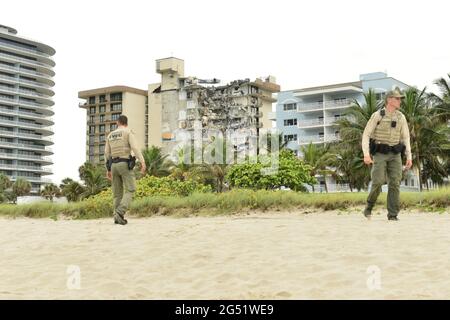 Surfside, USA. Juni 2021. SURFSIDE, FLORIDA - 24. JUNI: Polizeibeamter raub am Strand einen Teil des 12-stöckigen Champlain Towers South Condo-Gebäudes ab, das am 24. Juni 2021 in Surfside, Florida, teilweise einstürzten. Berichten zufolge entfielen 102 und 99 Menschen noch immer nicht auf die unbekannte Zahl der Verletzten, da die Such- und Rettungsbemühungen mit Rettungscrews aus den Bezirken Miami-Dade und Broward fortgesetzt werden. (Foto von JL/Sipa USA) Quelle: SIPA USA/Alamy Live News Stockfoto