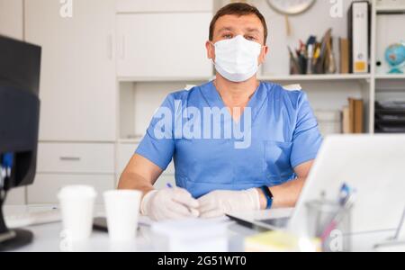 Hausarzt hört dem Patienten im Büro zu Stockfoto