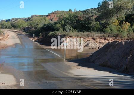 Überflutete Straße und Tiefenmesser im Palo Duro Canyon State Park, Texas Stockfoto