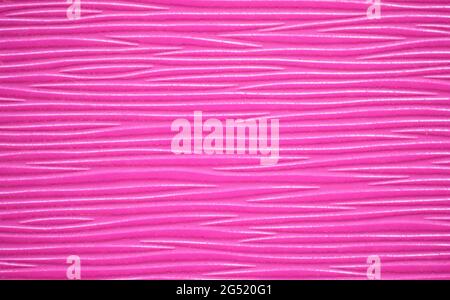 Eine gerippte Oberfläche mit einem wellenförmigen Muster aus natürlichem Holz, abgerundet in einer leuchtend violetten Farbe. Hintergrund, Muster, Textur. Stockfoto