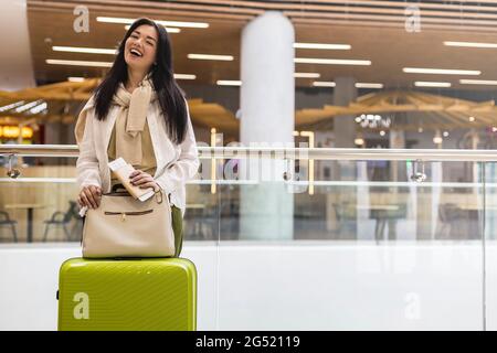 Glückliche Frau Reisende mit Dokumenten und Ticket wartet Abflug am internationalen Flughafen-Terminal Stockfoto