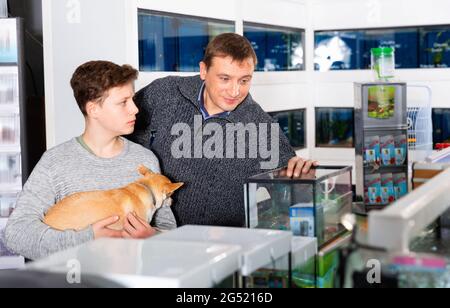 Positiver Teenager mit Hund von chihuahua züchten im Tiergeschäft Stockfoto