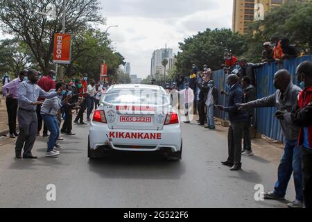 Kenianische Zuschauer feuern Safarirallye-Fahrer entlang des Uhuru Highway an, nachdem sie die offizielle Flaggenzeremonie der World Rally Championship (WRC)-Safaryallye 2021 auf dem KICC-Gelände verlassen hatten.Präsident Uhuru Kenyatta hat die World Rally Championship (WRC)-Safari-Rallye 2021 im Kenyatta International Convention Center in Nairobi, Kenia, markiert. Die Kenya Safari Rally feiert nach 19 Jahren ein Comeback und in diesem Jahr lockte die Meisterschaft 58 Teilnehmer aus der ganzen Welt an. Nach der Flagge des KICC fuhren die Autos nach Kasarani, um ihr Können der Öffentlichkeit zu präsentieren. Ein F Stockfoto