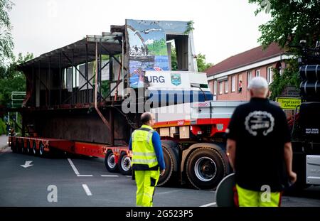 Bad Zwischenahn, Deutschland. Juni 2021. Ein Tieflader, beladen mit dem ersten Teil des in Längsrichtung geschnittenen Passagierschiffs „MS Oldenburg“, manövriert auf einer Straße. Nach zwei Stunden kam die erste Hälfte des ehemaligen Ausflugsdampfers in der Nacht auf einem Tieflader in Oldenburg an. (To dpa 'Sondertransport mit halbem Ex-Dampfer in Oldenburg angekommen') Quelle: Hauke-Christian Dittrich/dpa/Alamy Live News Stockfoto