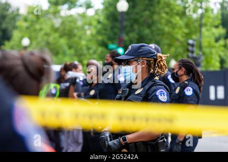 Washington, DC, USA, 24. Juni 2021. Im Bild: Polizeibeamte des Kapitols bilden eine Linie hinter dem gelben Tatortband, um friedliche Demonstranten zu überwachen, die während einer zivilen Ungehorsamsaktion im US-Kapitol aus Protest gegen den Filibuster festgenommen wurden. Demonstranten lehnen den Filibuster ab, weil er einer Minderheit von Senatoren erlaubt, Gesetze zu blockieren, die von der Mehrheit unterstützt werden. Kredit: Allison Bailey / Alamy Live Nachrichten Stockfoto