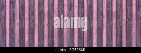 Alte Panorama-Holzwand aus wechselnden Brettern in lila und rosa Stockfoto