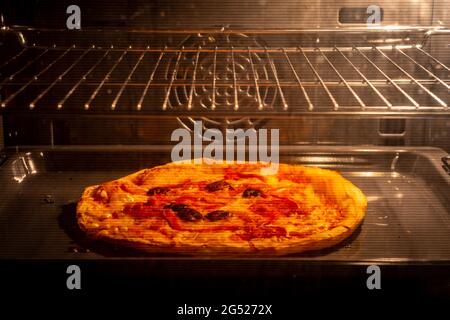 Tiefkühlpizza im Elektroofen aufgeheizt Stockfoto