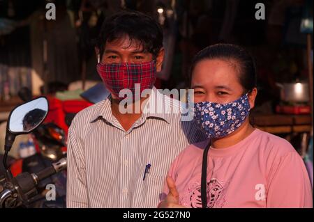 Porträt eines kambodschanischen Ehepaars mit stilvollen Gesichtsmasken/Deckungen während der Coronavirus-Pandemie. Kandal Market, Phnom Penh, Kambodscha. April 2020. © Kraig Lieb Stockfoto