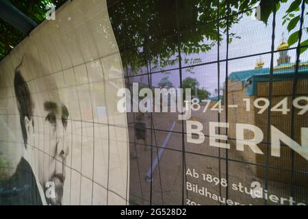 Darmstadt, Deutschland. Juni 2021. An einem Bauzaun vor dem Ausstellungsgebäude der Mathildenhöhe hängt ein teilweise transparentes Banner mit dem Porträt des deutschen Bildhauers, Malers und Architekten Bernhard Hoetger. Im Juli wird das Welterbekomitee den Antrag der Künstlerkolonie Mathildenhöhe auf Aufnahme in die UNESCO-Liste erörtern. Quelle: Andreas Arnold/dpa/Alamy Live News Stockfoto