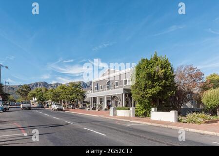 FRANSCHHOEK, SÜDAFRIKA - 12. APRIL 2021: Eine Straßenszene mit Geschäften und Fahrzeugen in Franschhoek in der Provinz Westkap Stockfoto