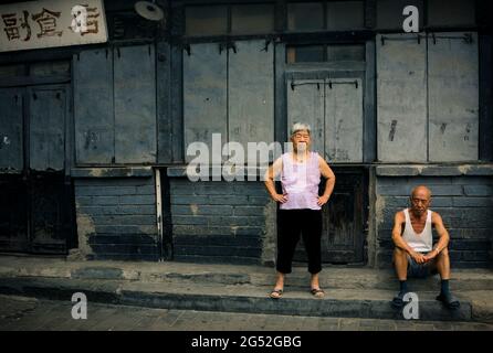 Ältere chinesen, die sich im Sommer in einer Hutong-Straße ausruhen, Peking, China. Stockfoto