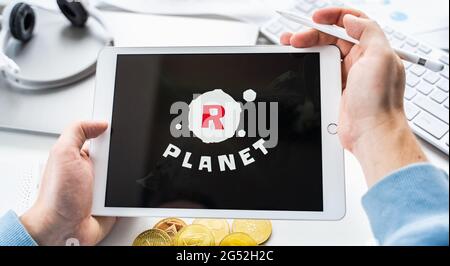 Russland Moskau 05.05.2021.man hält Tablet mit Logo der Gaming-Plattform R Planet. Krypto-Münzen, Token Bergbau Online-Spiel. NFT-Abstapelsystem. Krypto Stockfoto