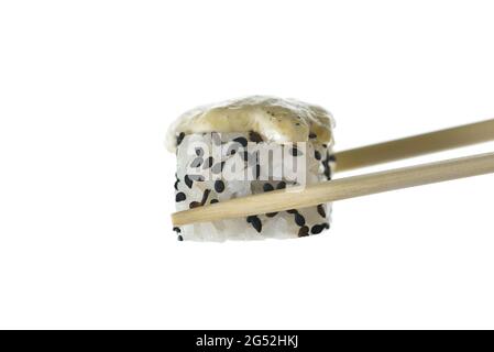 Essstäbchen halten gebackene Sushi-Rolle mit Sesam Stockfoto