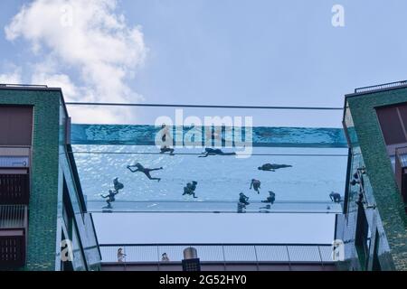London, Großbritannien. Juni 2021. Menschen im neu eröffneten Sky Pool, einem Schwimmbad, das 35 Meter über dem Boden zwischen zwei Wohngebäuden neben der US-Botschaft in Nine Elms aufgehängt ist. Es gilt als das weltweit erste Schwimmbad seiner Art und ist nur für Bewohner geöffnet. Stockfoto