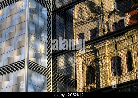 Kontrastierende Architektur in Leipzig: Ein Jugendstilgebäude, das sich in einer Glasfassade aus den 2010er Jahren neben einer Aluminiumverkleidung aus den 1960er Jahren widerspiegelt Stockfoto