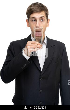 Junger, hübscher, großer, schlanker weißer Mann mit braunem Haar und einem Glas Wasser vor seinem Mund, isoliert auf weißem Hintergrund Stockfoto