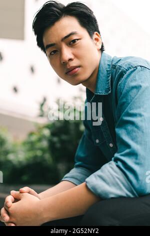 Asiatisch schöner junger Mann im grünen Garten Hintergrund Stockfoto