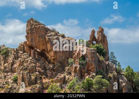 Dramatische Felsformationen mit einem herzförmigen Loch an den Calanques de Piana an der Westküste Korsikas Stockfoto