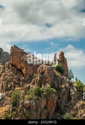 Dramatische Felsformationen mit einem herzförmigen Loch an den Calanques de Piana an der Westküste Korsikas Stockfoto