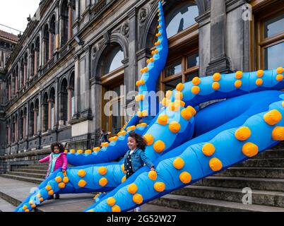 Edinburgh, Schottland, Großbritannien, 25. Juni 2021. Start des Edinburgh Science Festivals: Das Edinburgh Science Festival 2021 (26. Juni – 11. Juli) wird morgen eröffnet. Das 33. Edinburgh Science Festival umfasst eine interaktive Ausstellung namens Pale Blue Dot mit riesigen Kraken-Tentakeln im National Museum of Scotland als eines der wichtigsten Highlights in diesem Jahr. Das diesjährige Thema des Festivals lautet ‘One World: Science Connects US’. Im Bild: Freya Simpson und Gabby, 5 Jahre alt, ringen mit den Tentakeln, während der Oktopus aus dem Museum ausbricht Stockfoto