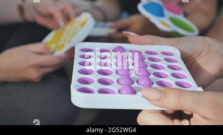 Mädchen spielen mit einfachen Grübchen entspannende Spielzeug und Pop it. Stockfoto