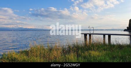 Bodensee Deutschland 2020. Juli Abend, See mit Möwe am Pier gegen Berge mit blauem Himmel und schönem Wetter Stockfoto