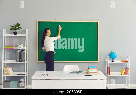 Der Lehrer schreibt eine Lektion an der Tafel in der Schule. Lernen, Bildung an einer Lyceum College-Schule für Kinder von Studenten zu lehren Stockfoto