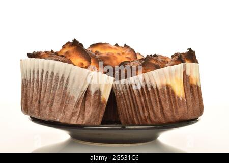 Drei duftende Schokoladenkuckuffins auf einer Untertasse, Nahaufnahme, isoliert auf Weiß. Stockfoto