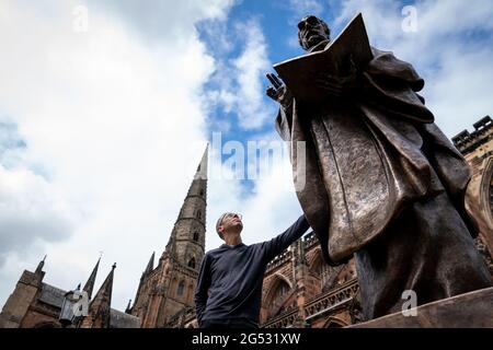 Der Bildhauer Peter Walker mit seiner Bronzestatue des Heiligen Tschad, des ersten Bischofs von Lichfield und des Gründers der Lichfield Cathedral, schließt seine Reise von einer Gießerei in Wales zur Kathedrale Close in der Lichfield Cathedral, Staffordshire. Bilddatum: Freitag, 25. Juni 2021. Stockfoto