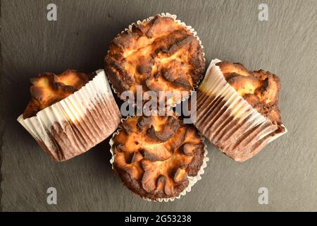 Drei duftende Schokoladenkuckuffins auf einem Schieferbrett, Nahaufnahme, Draufsicht. Stockfoto