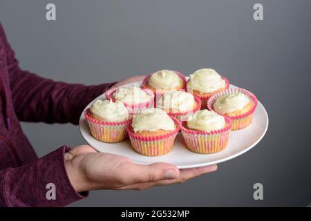 Teller mit hausgemachten, zuckerglasierten Cupcakes, UK Stockfoto