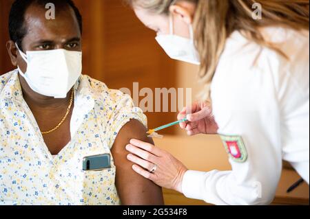 Hamburg, Deutschland. Juni 2021. Im Duckdalben Seemannsverein wird ein Seefahrer gegen das Coronavirus geimpft. Seeleute können sich am 25.06.2021 im Seemannsclub Duckdalben vom Port Medical Service gegen das Coronavirus impfen lassen. Quelle: Daniel Reinhardt/dpa/Alamy Live News Stockfoto