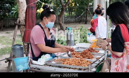 Käufer und Verkäufer authentisches Geld wechseln die Hände Klong Toey Market BangkokThailand die Wirtschaft der Lebensmittelverkäufe Menschen kaufen Mittagessen Rama 4 Kreuzung Stockfoto